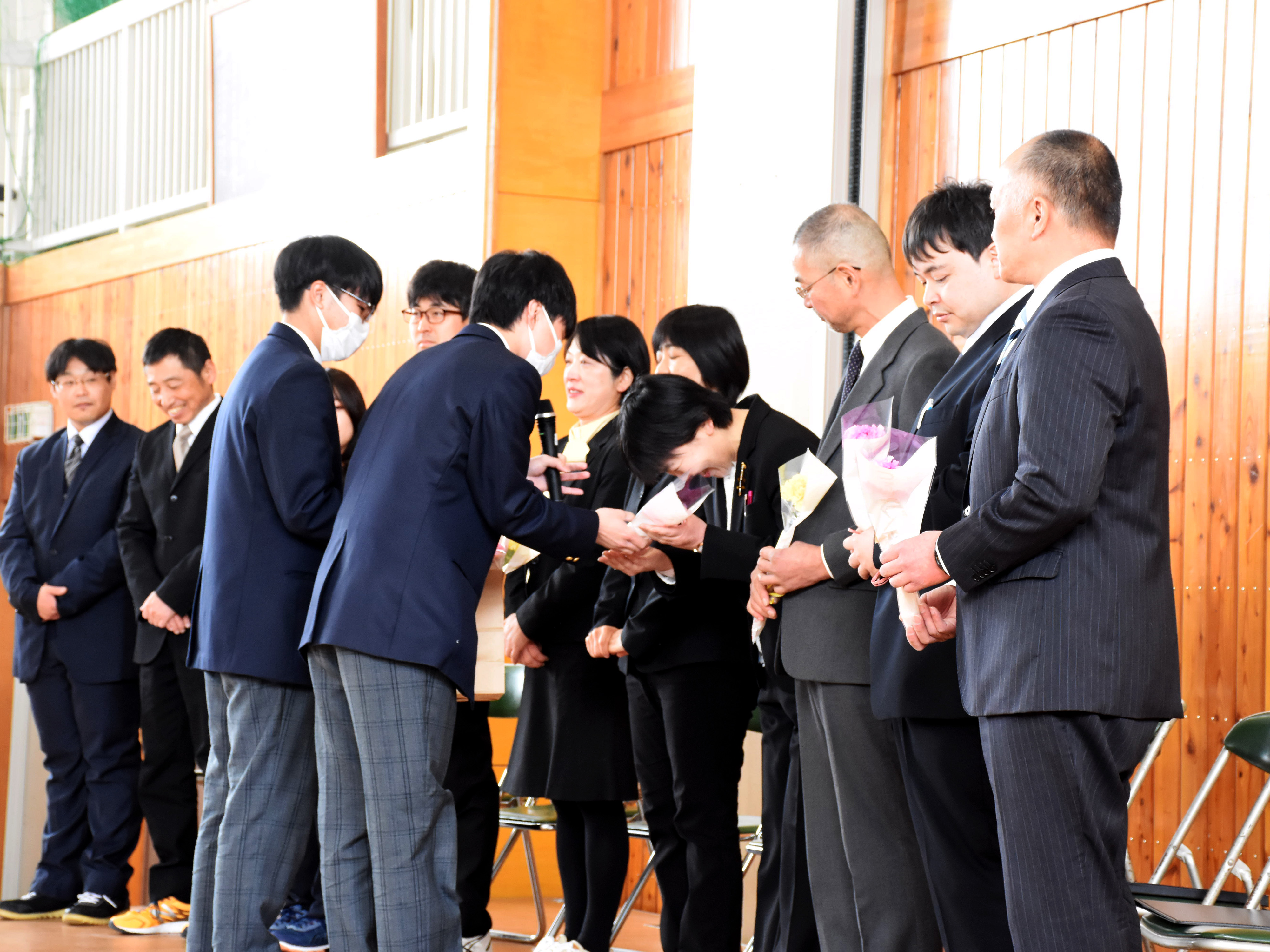 離任式にて生徒から花束を受け取る先生